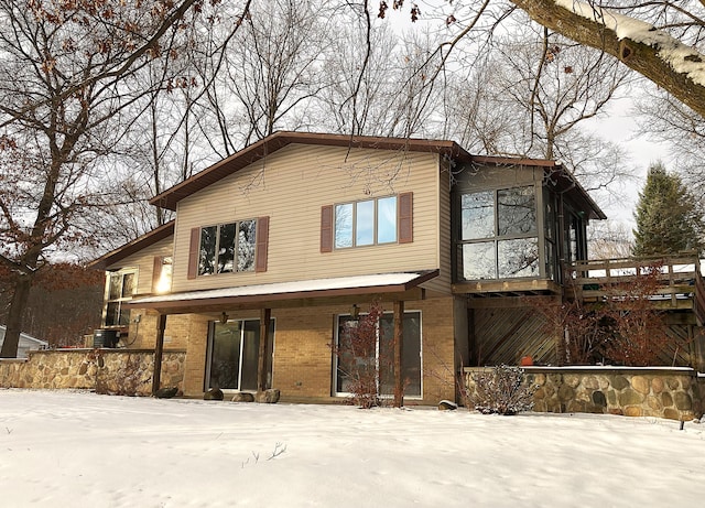 view of snow covered back of property