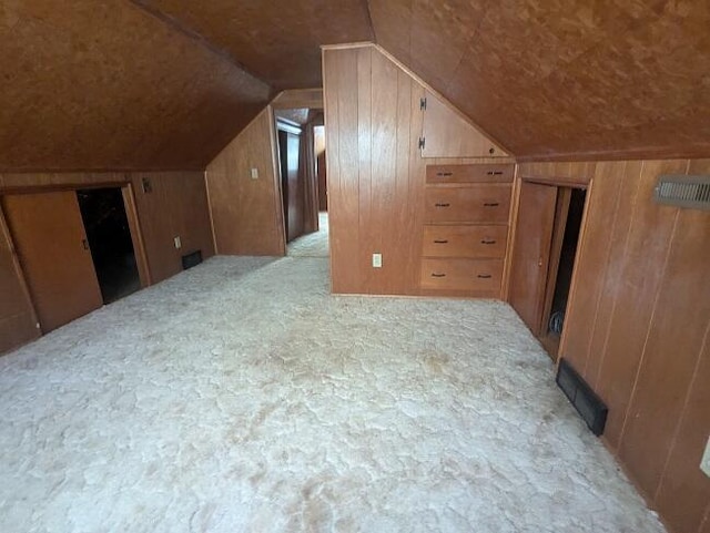 additional living space with lofted ceiling and wooden walls