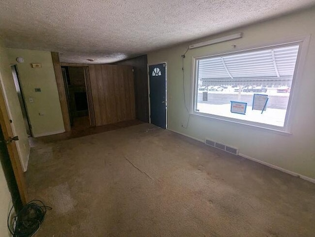 foyer entrance with carpet flooring and a textured ceiling