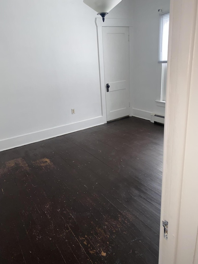 spare room featuring dark hardwood / wood-style floors and baseboard heating