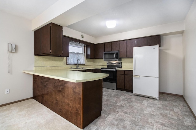 kitchen with dark brown cabinets, kitchen peninsula, appliances with stainless steel finishes, and sink