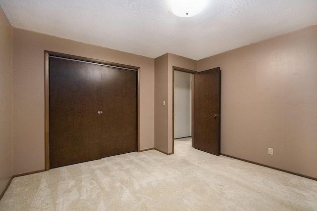 unfurnished bedroom with light colored carpet and a closet