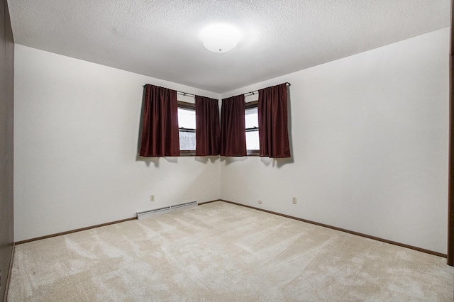 carpeted empty room featuring a textured ceiling and a baseboard heating unit