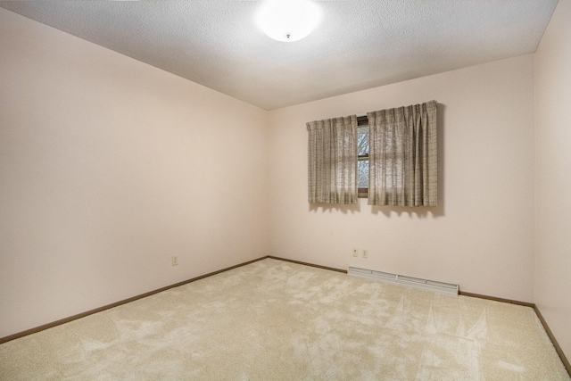 carpeted empty room featuring a baseboard radiator and a textured ceiling