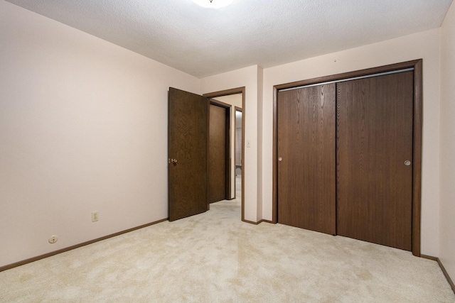 unfurnished bedroom with light carpet and a closet