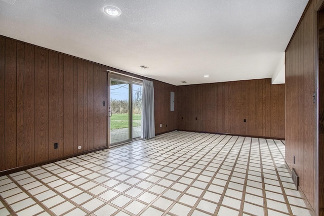 unfurnished room featuring wood walls