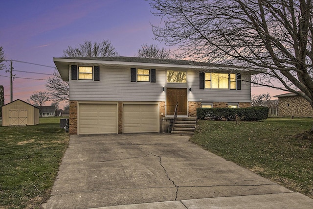 raised ranch featuring a garage, a yard, and a storage unit