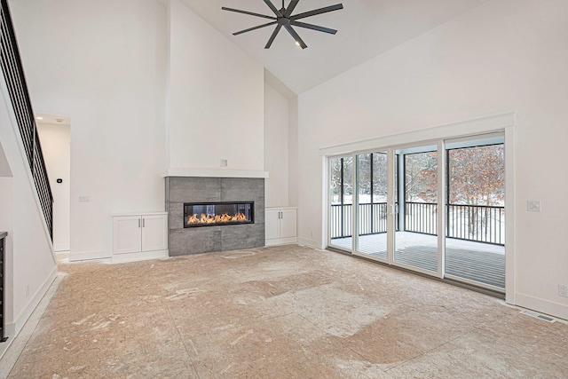 unfurnished living room with ceiling fan, a fireplace, and high vaulted ceiling