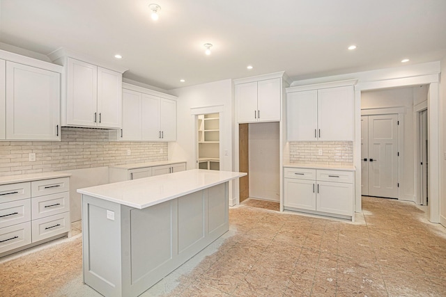 kitchen with white cabinetry, tasteful backsplash, and a kitchen island