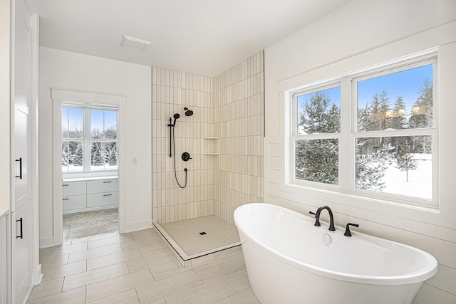 bathroom with shower with separate bathtub and tile patterned floors