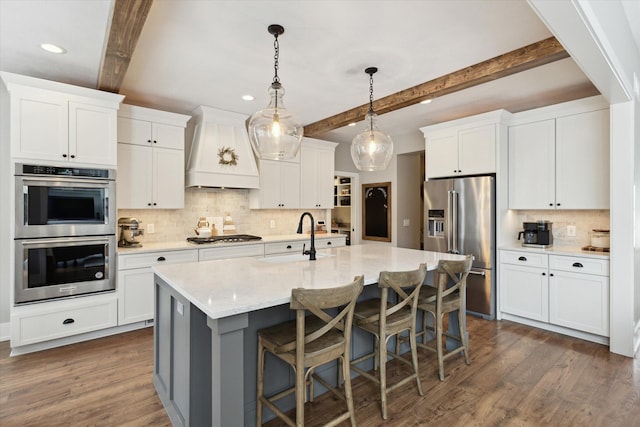 kitchen with white cabinetry, beamed ceiling, custom range hood, and stainless steel appliances