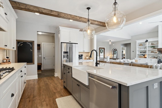 kitchen with sink, white cabinetry, backsplash, and stainless steel appliances