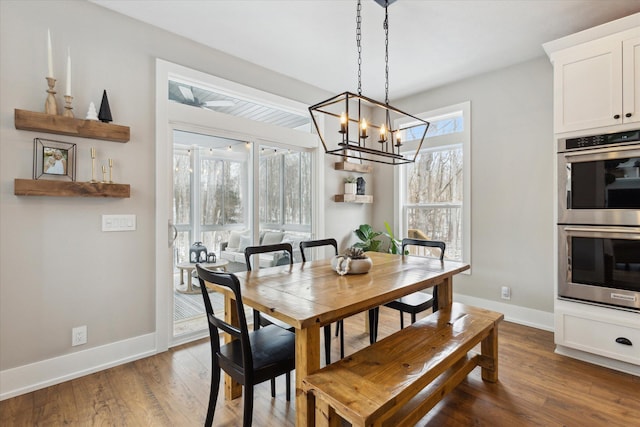 dining area featuring a notable chandelier and dark hardwood / wood-style flooring