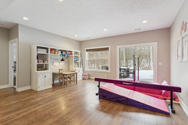 game room with hardwood / wood-style floors and a textured ceiling