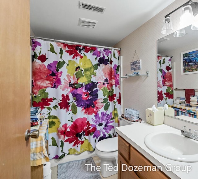 bathroom featuring vanity, toilet, and curtained shower