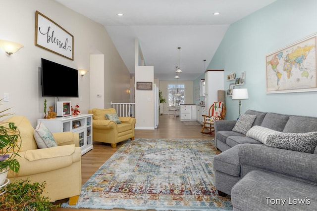 living room featuring lofted ceiling and light hardwood / wood-style flooring