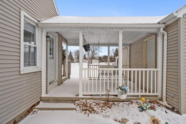 snow covered patio featuring covered porch