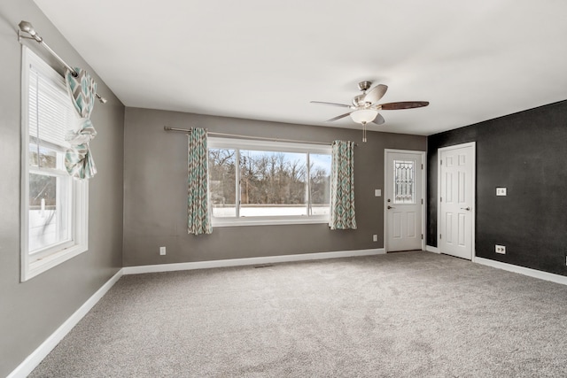 carpeted spare room featuring ceiling fan