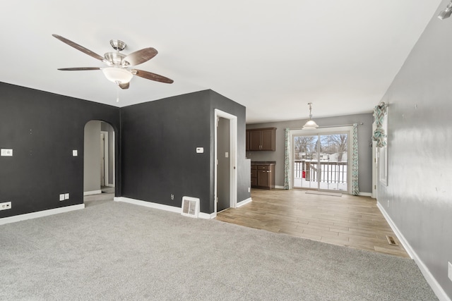 unfurnished living room with light carpet and ceiling fan