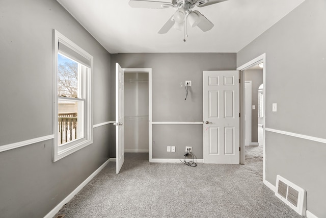 unfurnished bedroom featuring light colored carpet, a closet, and ceiling fan