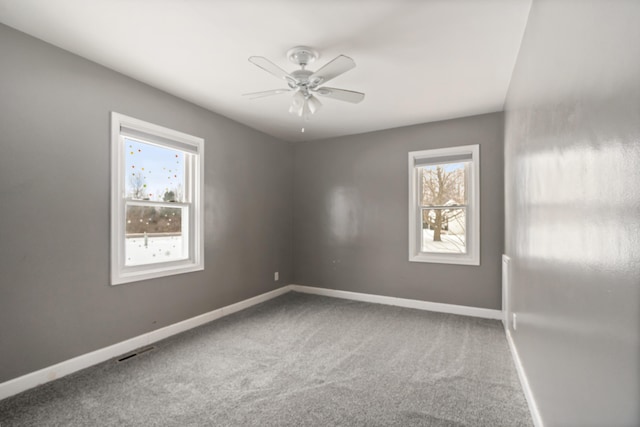 unfurnished room featuring carpet floors, a wealth of natural light, and ceiling fan