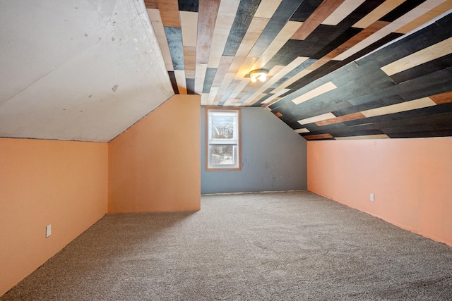 additional living space featuring vaulted ceiling and carpet floors