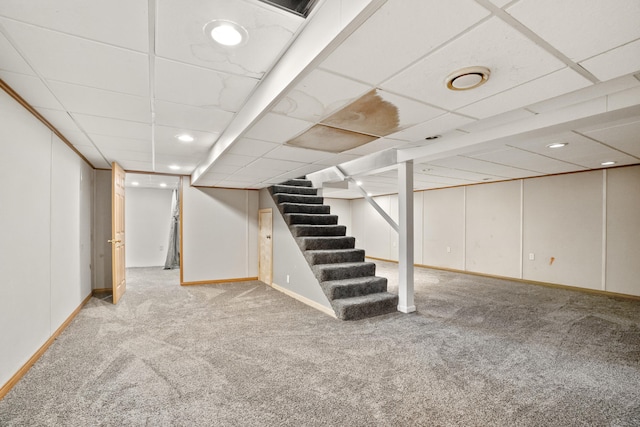 basement featuring carpet floors and a drop ceiling