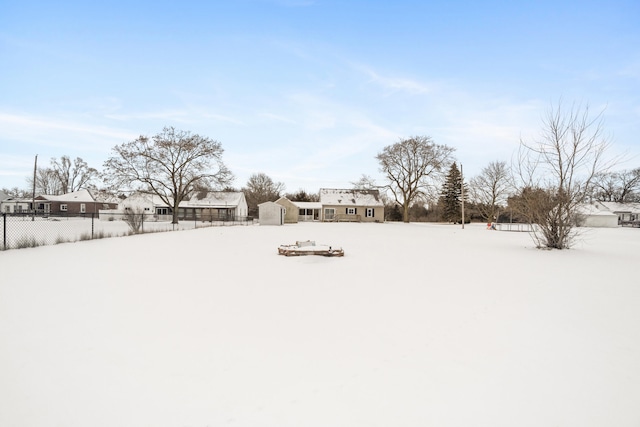 yard covered in snow with a storage shed