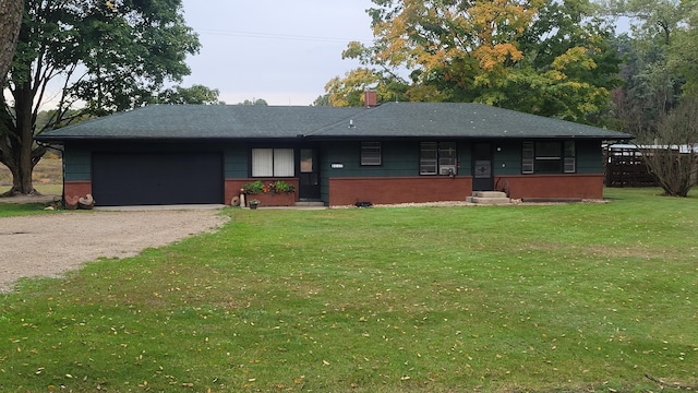 ranch-style house featuring a garage and a front lawn