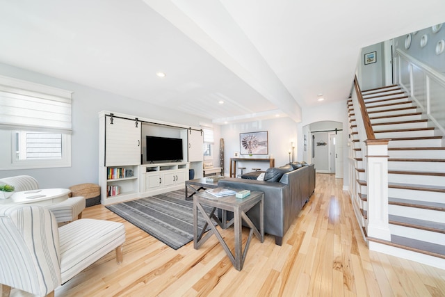 living room with beam ceiling and light hardwood / wood-style flooring