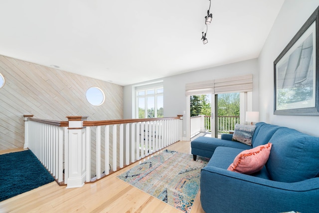 living room with wood-type flooring and wooden walls