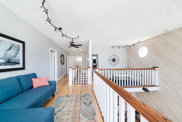 hall with light hardwood / wood-style flooring and wood walls