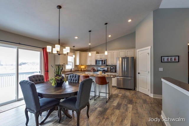 dining area featuring dark hardwood / wood-style flooring, sink, high vaulted ceiling, and a chandelier