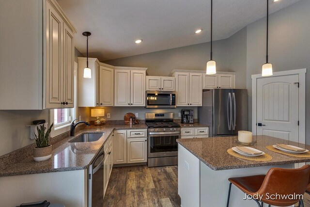 kitchen with pendant lighting, sink, dark wood-type flooring, appliances with stainless steel finishes, and a kitchen island