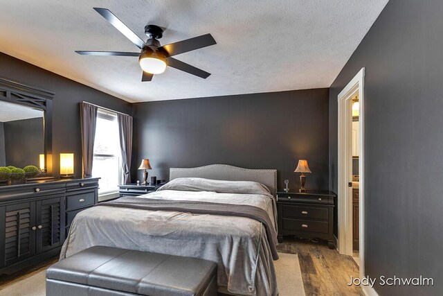 bedroom featuring ceiling fan, a textured ceiling, and light wood-type flooring