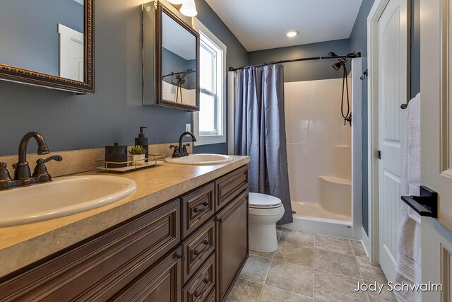 bathroom featuring tile patterned flooring, toilet, vanity, and walk in shower