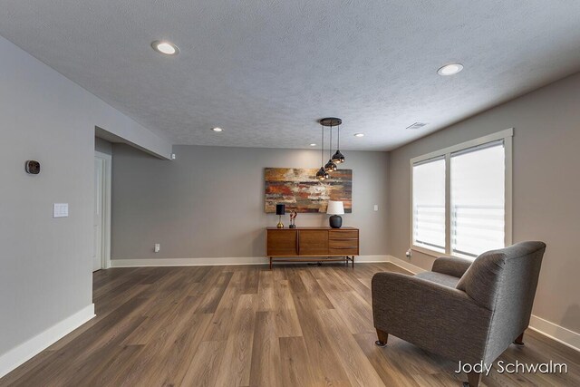 sitting room with hardwood / wood-style floors and a textured ceiling