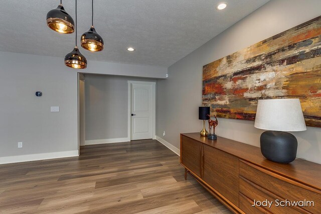 hallway featuring hardwood / wood-style flooring and a textured ceiling