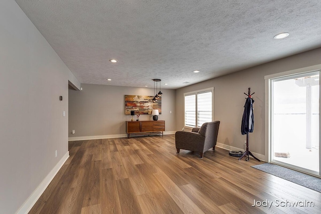 living area featuring hardwood / wood-style flooring and a textured ceiling