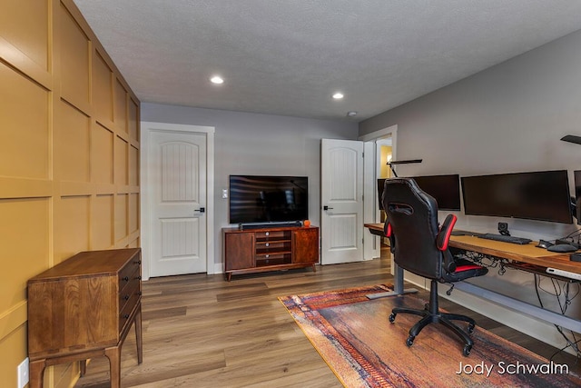 office with hardwood / wood-style flooring and a textured ceiling