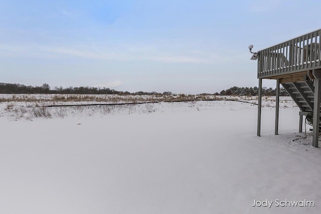 yard covered in snow with a deck