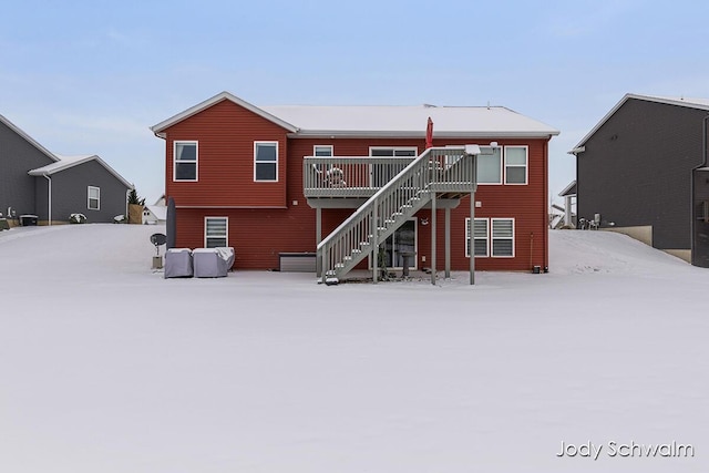 snow covered rear of property featuring a deck