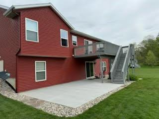 rear view of property with a yard, stairway, and a patio