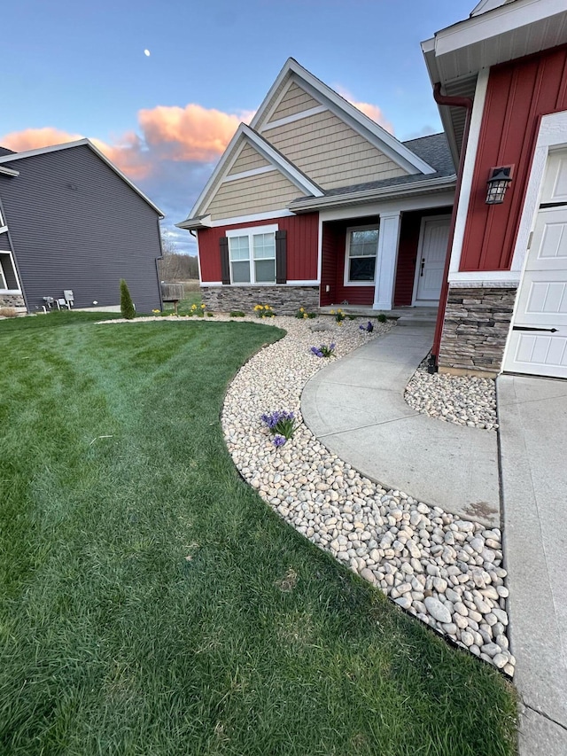 exterior space featuring stone siding, board and batten siding, and a front yard