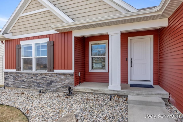 entrance to property featuring a porch and stone siding