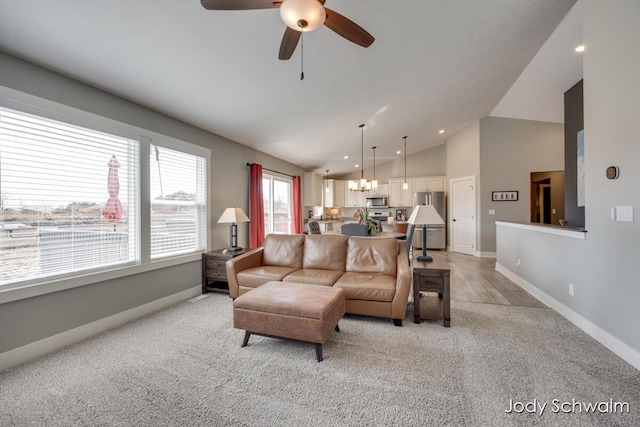 living area featuring light colored carpet, baseboards, ceiling fan, and vaulted ceiling