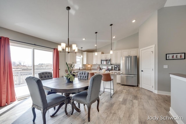 dining area with high vaulted ceiling, light wood-style flooring, recessed lighting, baseboards, and a chandelier