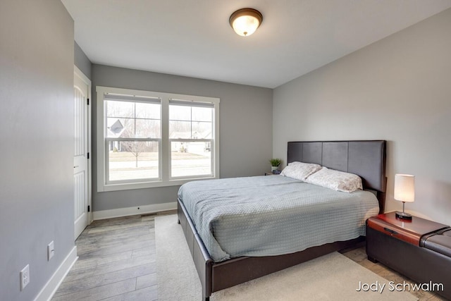 bedroom featuring baseboards and light wood finished floors