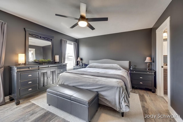 bedroom with a ceiling fan, wood finished floors, and baseboards