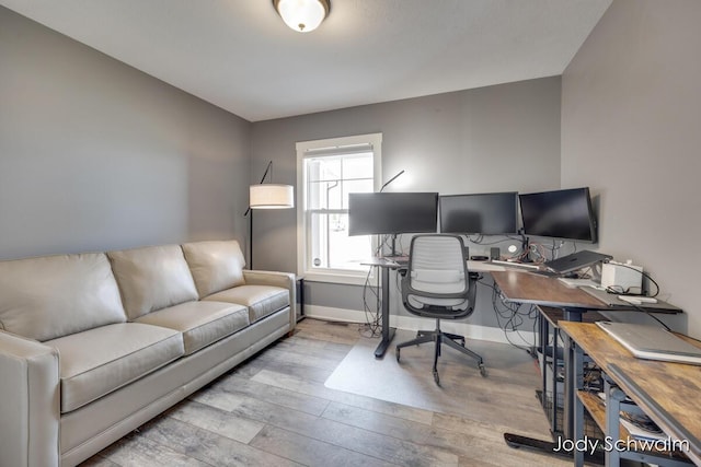 home office with baseboards and wood finished floors